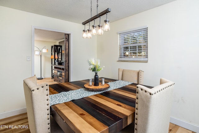 dining space featuring hardwood / wood-style floors and a textured ceiling