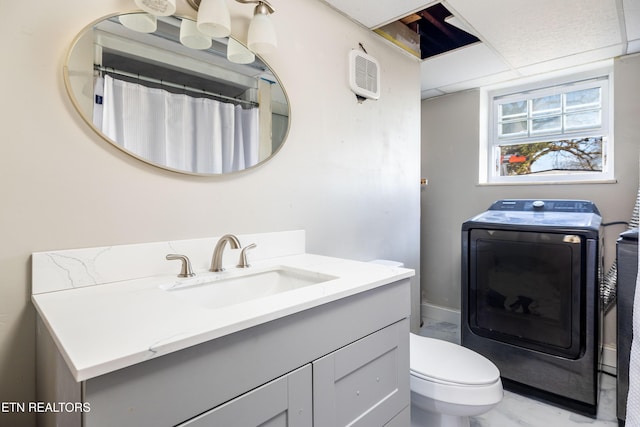 bathroom featuring toilet, vanity, and washer / clothes dryer