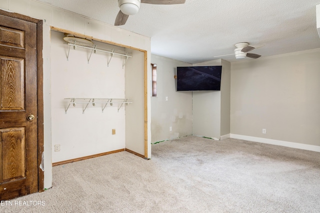 interior space with ceiling fan, light colored carpet, and a textured ceiling