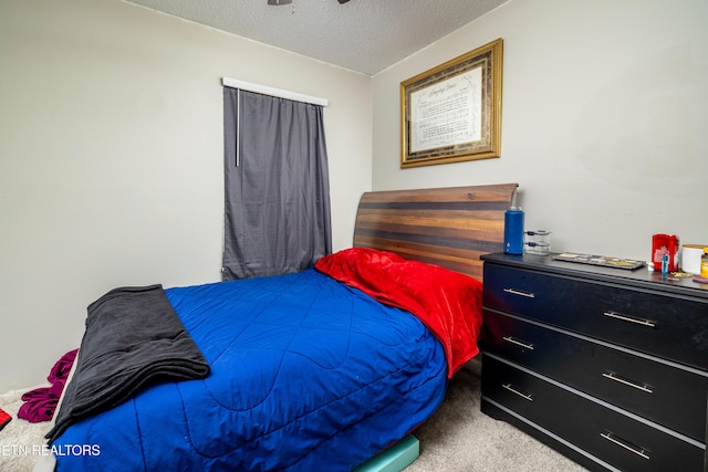 bedroom featuring light carpet and a textured ceiling