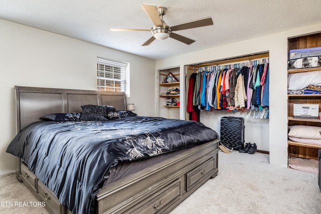 carpeted bedroom with ceiling fan, a closet, and a textured ceiling