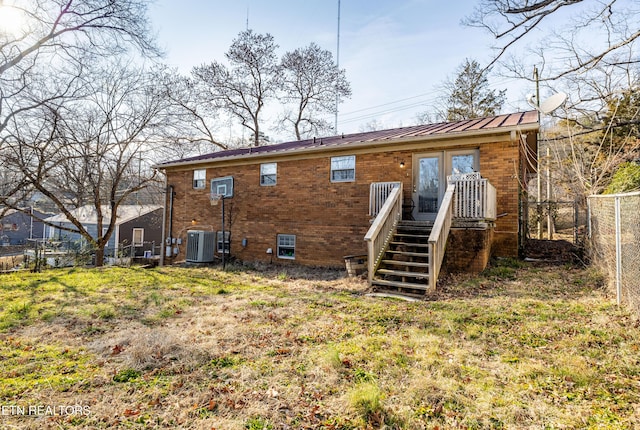 back of house with a lawn and central air condition unit