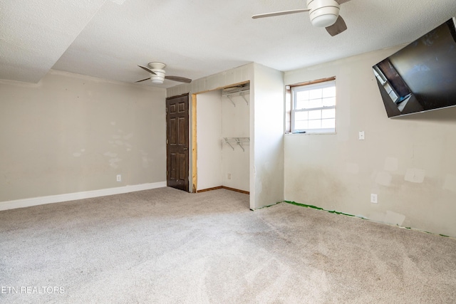 unfurnished bedroom featuring light carpet, ceiling fan, a closet, and a textured ceiling