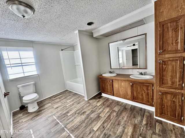 full bathroom with crown molding, tub / shower combination, vanity, wood-type flooring, and a textured ceiling