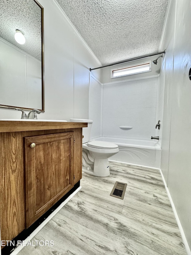 full bathroom with vanity, tub / shower combination, hardwood / wood-style floors, and a textured ceiling