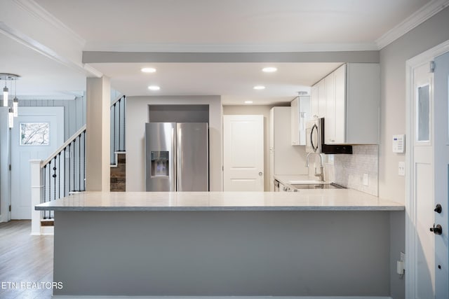 kitchen featuring crown molding, kitchen peninsula, stainless steel fridge with ice dispenser, and white cabinets