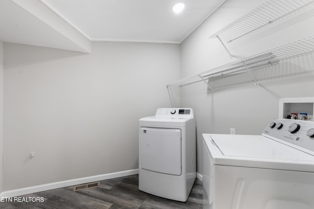 washroom featuring dark hardwood / wood-style flooring and washer and clothes dryer