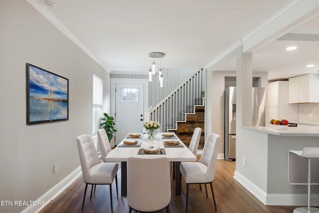 dining area featuring hardwood / wood-style flooring and crown molding