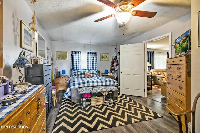 bedroom with ceiling fan, dark hardwood / wood-style floors, and a textured ceiling