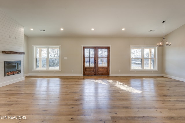 unfurnished living room with plenty of natural light, a fireplace, and light hardwood / wood-style floors