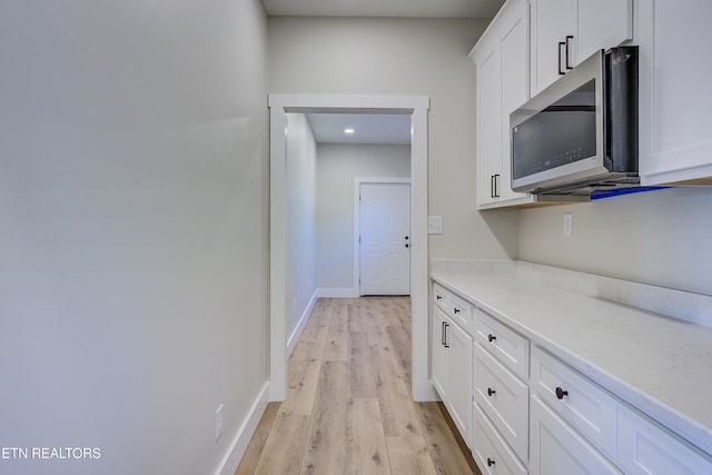 interior space with white cabinets and light hardwood / wood-style floors