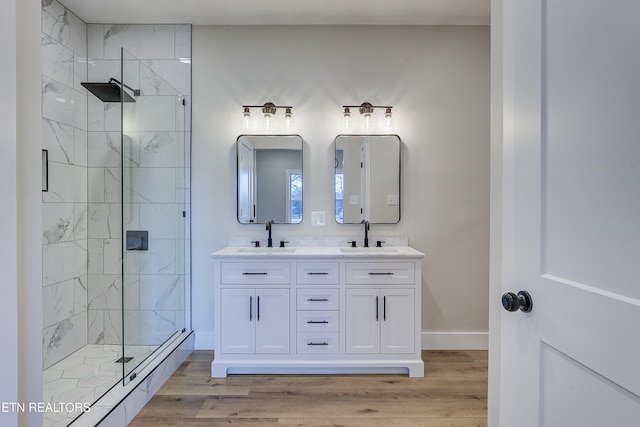 bathroom with hardwood / wood-style flooring, vanity, and a shower with door