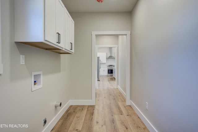 washroom with cabinets, washer hookup, light hardwood / wood-style flooring, and electric dryer hookup