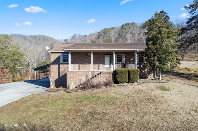 view of front of house with a carport, a porch, and a front lawn