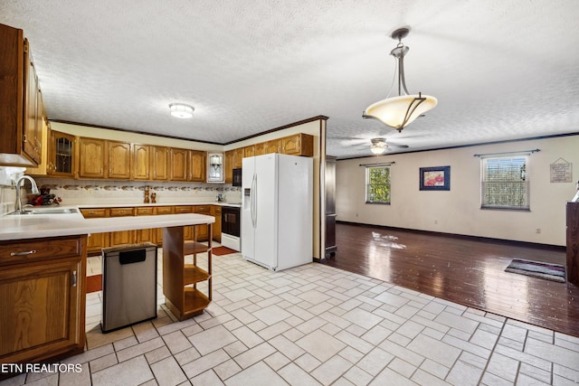 kitchen featuring sink, dishwasher, hanging light fixtures, white fridge with ice dispenser, and a healthy amount of sunlight