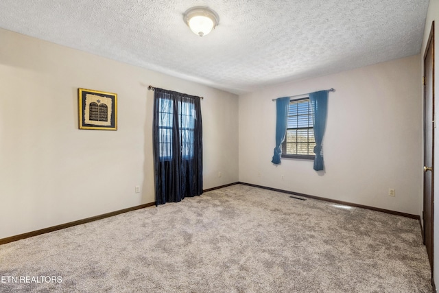 spare room with carpet floors and a textured ceiling