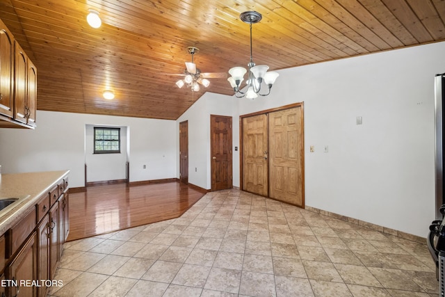 kitchen with lofted ceiling, hanging light fixtures, light tile patterned floors, a notable chandelier, and wood ceiling