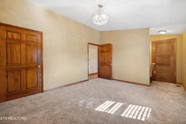 unfurnished bedroom featuring a chandelier and light carpet