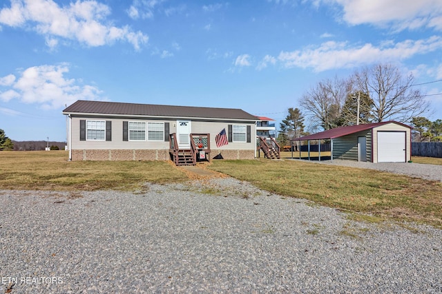 manufactured / mobile home with an outbuilding, a garage, a front yard, and a carport