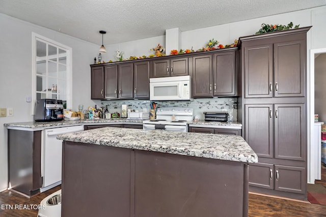 kitchen featuring hanging light fixtures, white appliances, dark hardwood / wood-style floors, and a center island