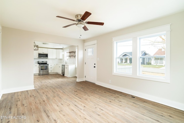 unfurnished living room featuring ceiling fan and light hardwood / wood-style floors