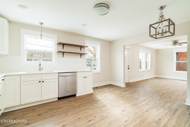 kitchen featuring sink, light hardwood / wood-style flooring, white cabinetry, decorative light fixtures, and stainless steel dishwasher