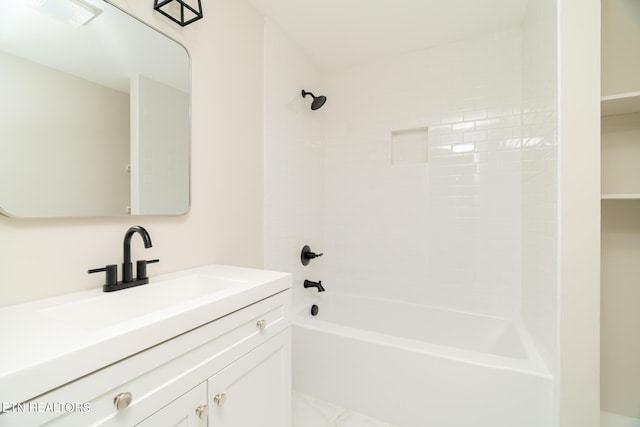 bathroom featuring tiled shower / bath and vanity