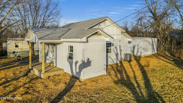 exterior space featuring cooling unit and a lawn