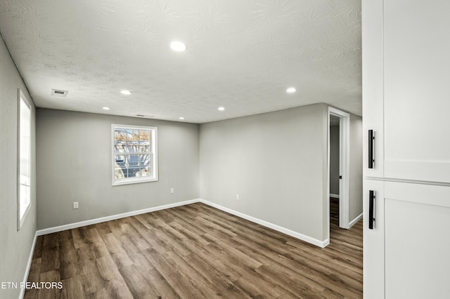 spare room with hardwood / wood-style flooring and a textured ceiling