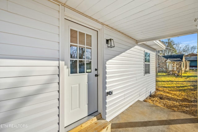 property entrance with a lawn and a patio area