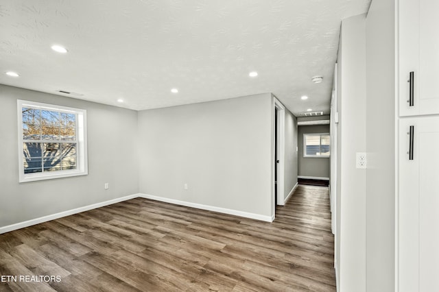 empty room with hardwood / wood-style floors and a textured ceiling