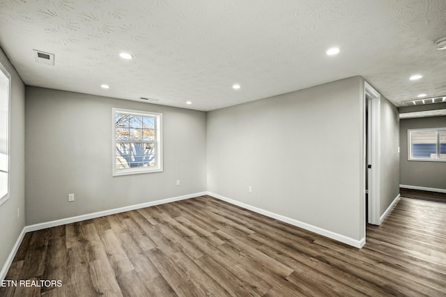 empty room featuring wood-type flooring and a textured ceiling