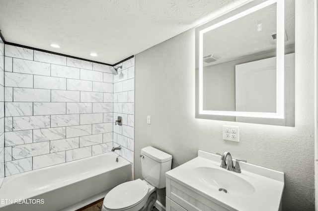 full bathroom with tiled shower / bath, vanity, toilet, and a textured ceiling