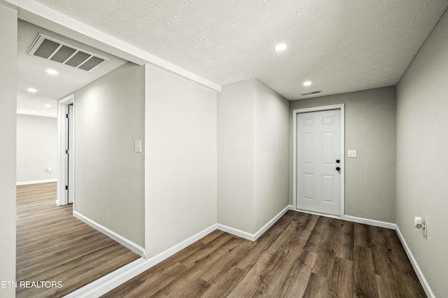 interior space featuring dark wood-type flooring and a textured ceiling