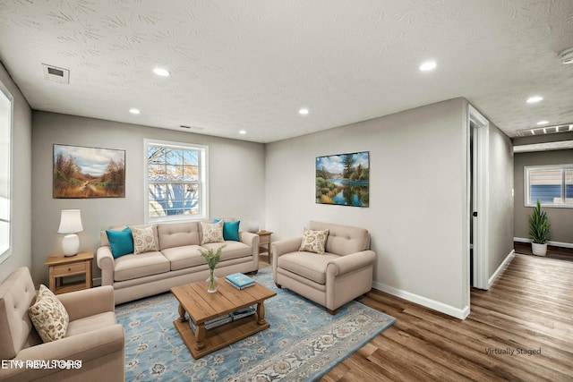 living room with wood-type flooring and a textured ceiling