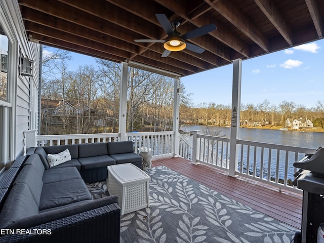 wooden deck with a water view, ceiling fan, an outdoor hangout area, and area for grilling