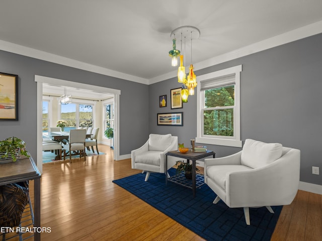 sitting room with crown molding, a wealth of natural light, and wood-type flooring