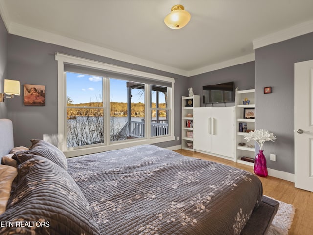 bedroom with crown molding and light wood-type flooring