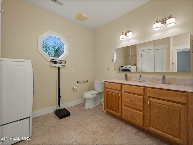 bathroom with toilet, tile patterned floors, vanity, and washer / clothes dryer