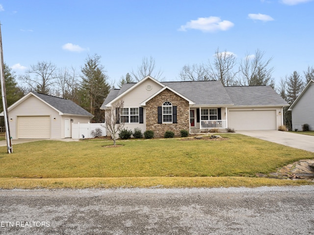 ranch-style home with a porch, a garage, a front yard, and an outdoor structure