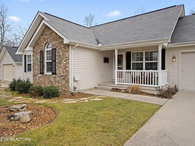 view of front facade featuring a porch, a garage, and a front lawn