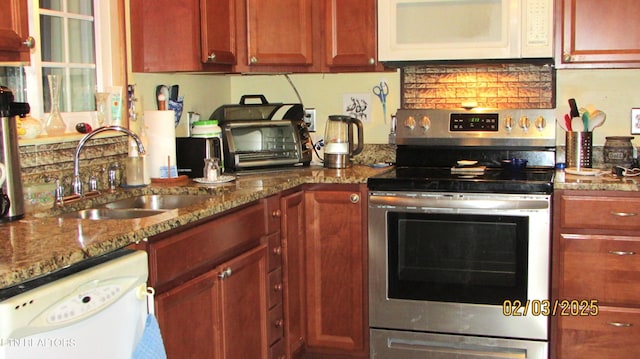 kitchen with light stone counters, white appliances, and sink