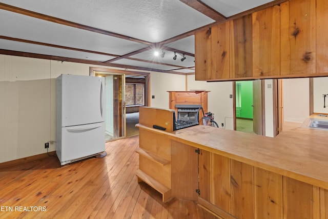 kitchen with white refrigerator, sink, and light wood-type flooring