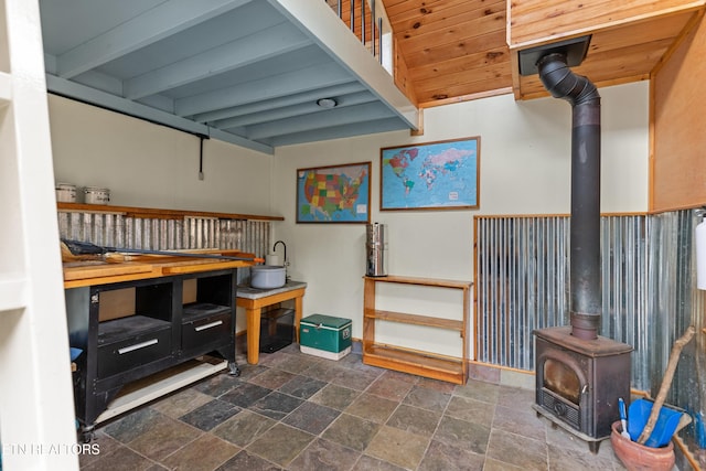 interior space with a wood stove and beam ceiling