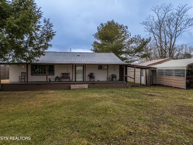 back of house with a yard, a carport, and a porch