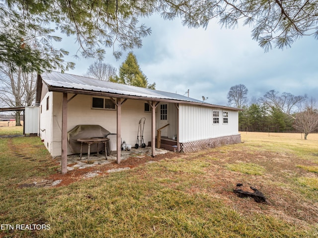 back of property featuring a yard