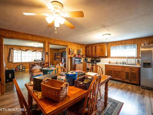 dining space with hardwood / wood-style floors, plenty of natural light, and wooden walls