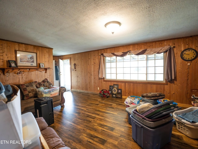 living room featuring plenty of natural light, dark hardwood / wood-style floors, a textured ceiling, and wood walls