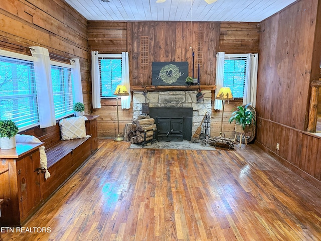 unfurnished living room featuring hardwood / wood-style flooring and wood walls