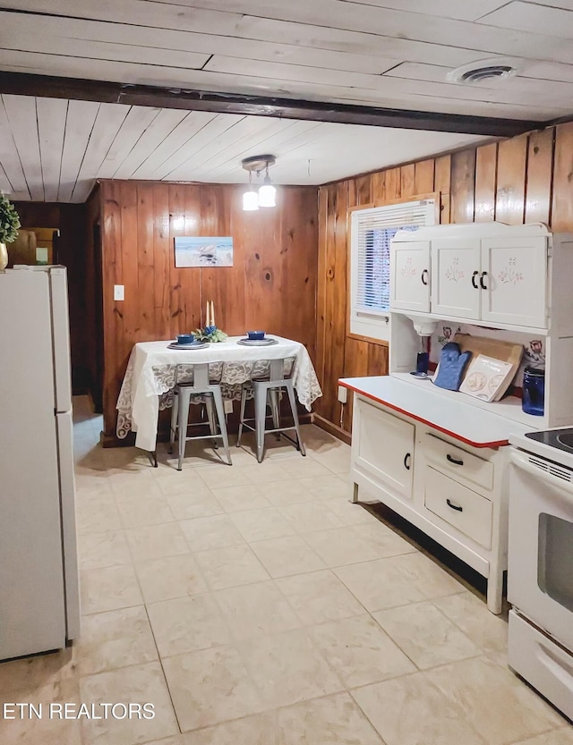 bedroom featuring wooden walls and white refrigerator